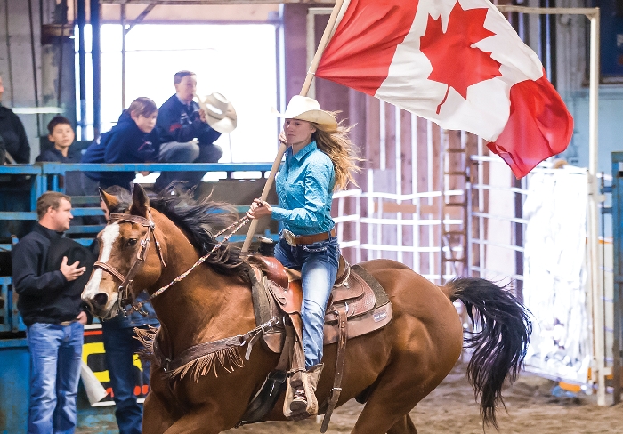 Joelle Garvey carries the Canadian flag during the opening of the Dodge City Days Rodeo in Wapella last year. Kim Poole took this great photo.